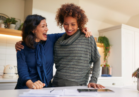 Excited couple with a signed refinance agreement on the table in front of them