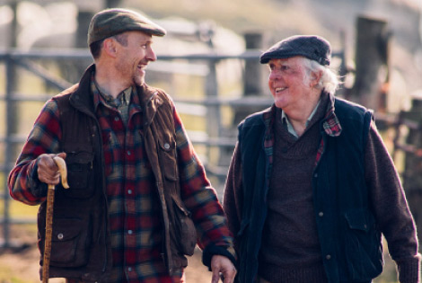 Two older farmers discussing Heartland's farm transition loan.